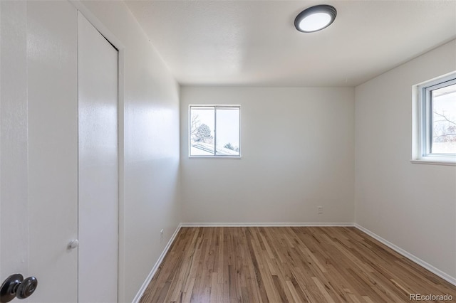 spare room featuring wood finished floors and baseboards