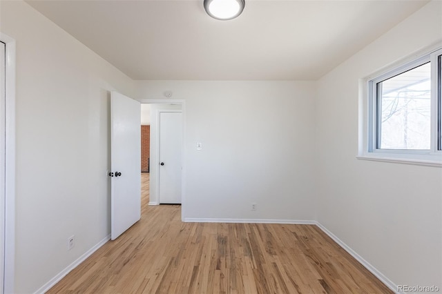 unfurnished room featuring baseboards and light wood-type flooring