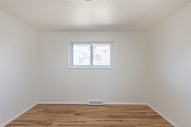 empty room with visible vents, baseboards, and light wood-style floors