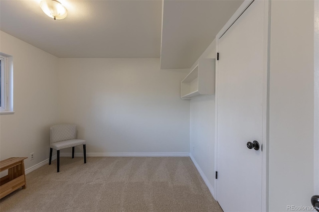 interior space featuring light colored carpet and baseboards