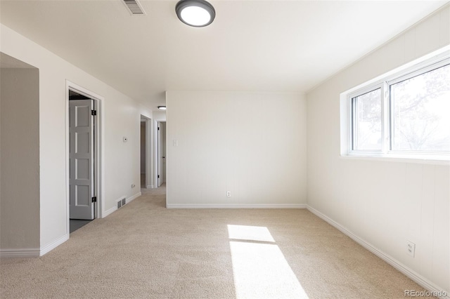 carpeted spare room with visible vents and baseboards