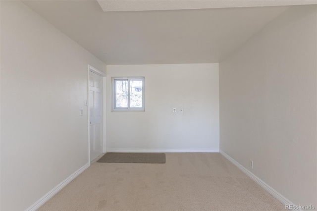 empty room with baseboards and light carpet