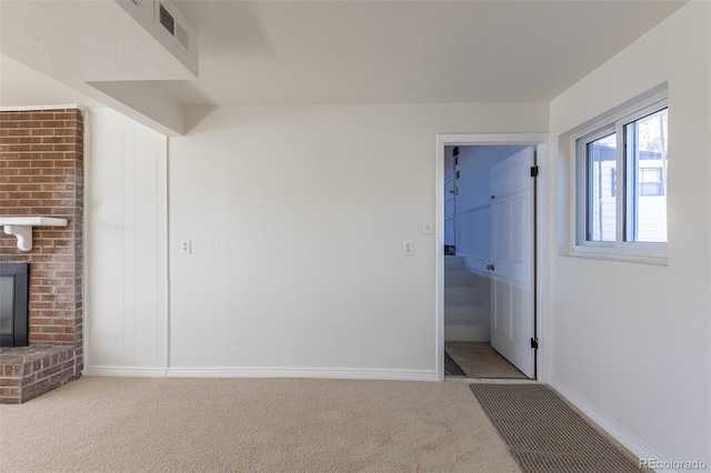 interior space featuring a brick fireplace, baseboards, visible vents, and carpet floors