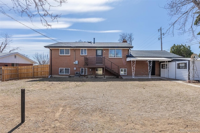 back of property featuring brick siding, a chimney, and fence