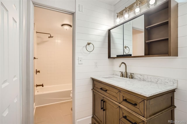 full bathroom with vanity, toilet, wooden walls, and tiled shower / bath