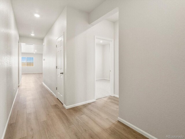 hallway featuring baseboards and wood finished floors