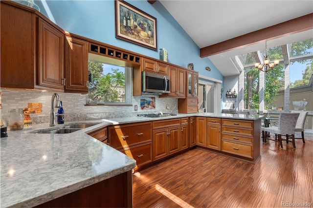 7300 W Stetson Pl Unit 46, Littleton, CO 80123 - kitchen featuring stainless steel appliances, a sink, a peninsula, a chandelier, and backsplash