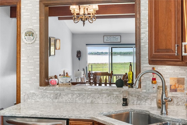 7300 W Stetson Pl Unit 46, Littleton, CO 80123 - kitchen with a sink, dishwasher, decorative backsplash, a chandelier, and brown cabinets