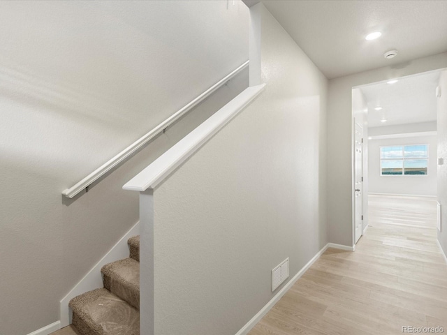 staircase with hardwood / wood-style floors