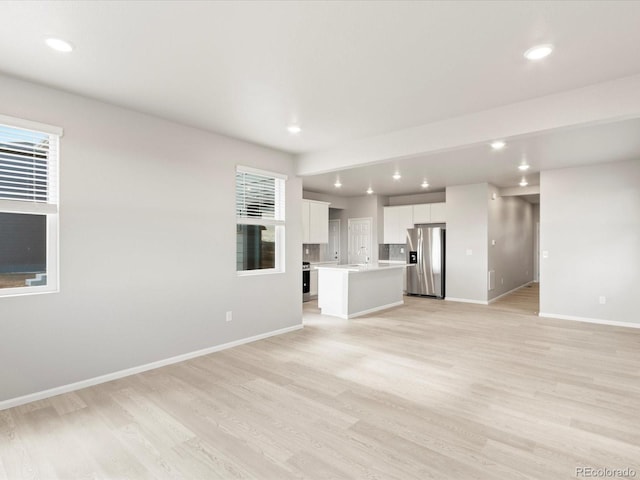 unfurnished living room featuring light hardwood / wood-style floors and sink