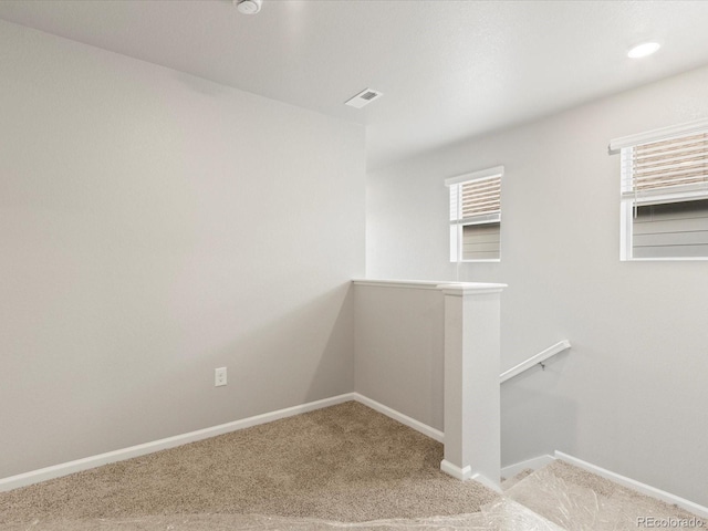 staircase featuring plenty of natural light and carpet flooring