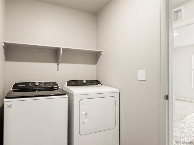 clothes washing area with carpet floors and independent washer and dryer