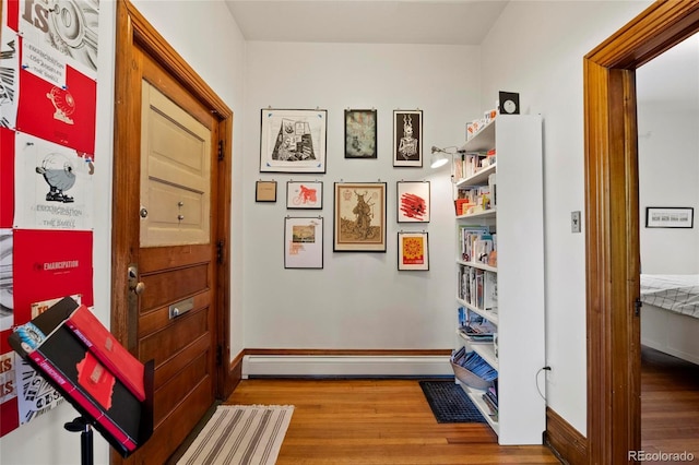 328 S Lincoln St, Denver, CO 80209 - corridor with baseboard heating, wood finished floors, and baseboards