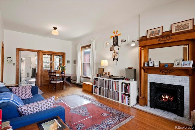 328 S Lincoln St, Denver, CO 80209 - living area featuring wood finished floors, a brick fireplace, and radiator heating unit