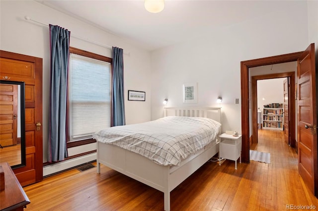328 S Lincoln St, Denver, CO 80209 - bedroom with light wood-style flooring and a baseboard heating unit