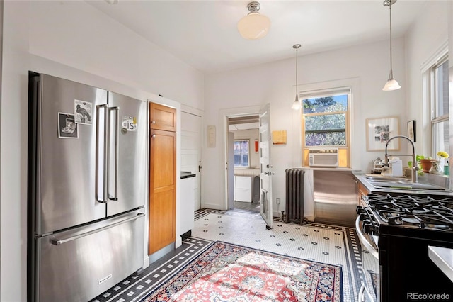 328 S Lincoln St, Denver, CO 80209 - kitchen with stainless steel appliances, a sink, radiator heating unit, pendant lighting, and light flooring