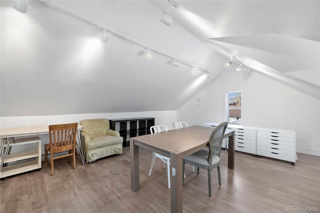 328 S Lincoln St, Denver, CO 80209 - dining area featuring rail lighting, vaulted ceiling, and wood finished floors