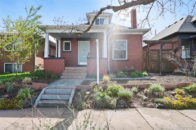 328 S Lincoln St, Denver, CO 80209 - bungalow with covered porch, brick siding, and a chimney