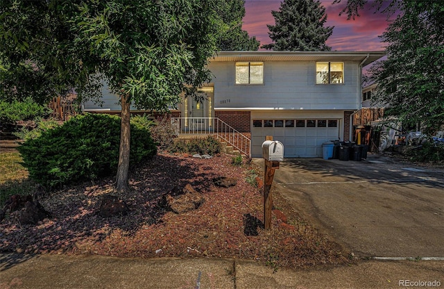 10171 W 69th Ave, Arvada, CO 80004 - tri-level home featuring a garage, concrete driveway, and brick siding