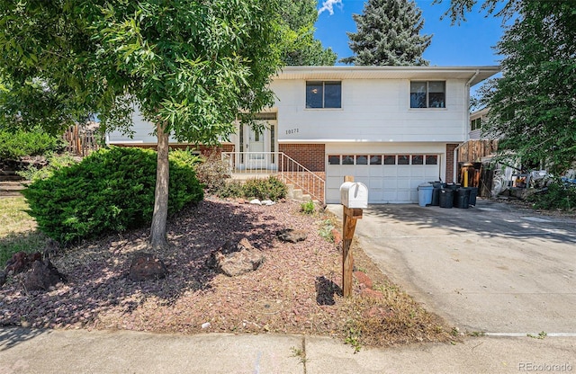 10171 W 69th Ave, Arvada, CO 80004 - view of front facade featuring brick siding, an attached garage, and driveway