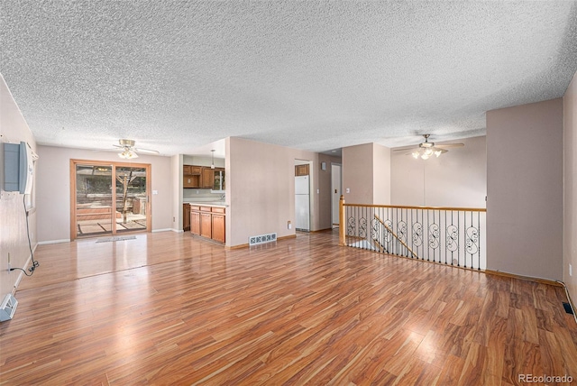10171 W 69th Ave, Arvada, CO 80004 - unfurnished living room featuring ceiling fan, light wood-style floors, and a textured ceiling