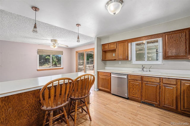 10171 W 69th Ave, Arvada, CO 80004 - kitchen featuring dishwasher, brown cabinets, hanging light fixtures, light countertops, and a textured ceiling