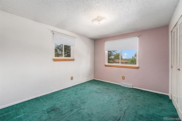 10171 W 69th Ave, Arvada, CO 80004 - unfurnished bedroom featuring a closet, multiple windows, a textured ceiling, and carpet floors
