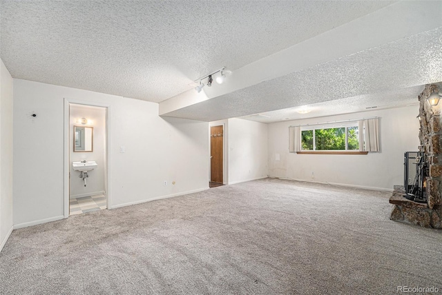 10171 W 69th Ave, Arvada, CO 80004 - unfurnished living room with a textured ceiling, carpet flooring, track lighting, and a wood stove