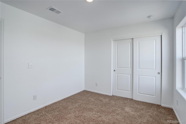 unfurnished bedroom with carpet and a closet