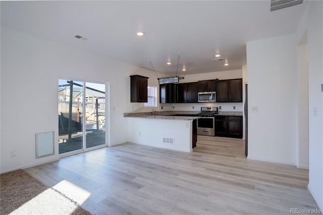 kitchen featuring kitchen peninsula, appliances with stainless steel finishes, dark brown cabinetry, and light hardwood / wood-style flooring