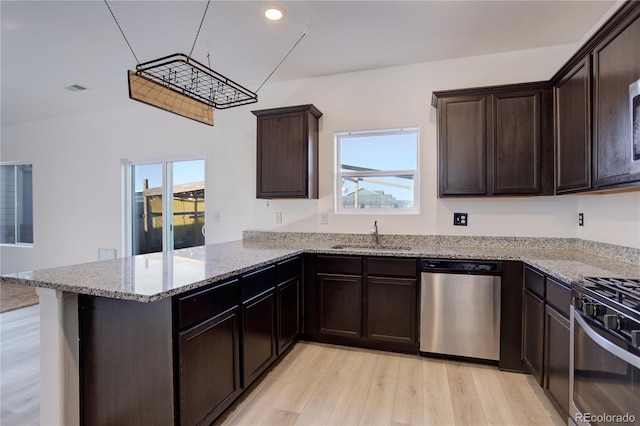 kitchen with kitchen peninsula, appliances with stainless steel finishes, plenty of natural light, and sink