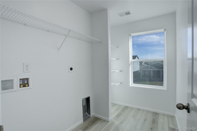 laundry room featuring electric dryer hookup, hookup for a washing machine, and light hardwood / wood-style floors