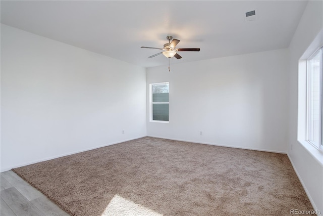 spare room featuring ceiling fan and light colored carpet