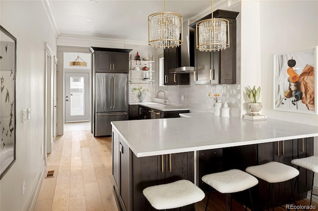 3142 W 26th Ave, Denver, CO 80211 - kitchen with stainless steel appliances, light countertops, a chandelier, a peninsula, and ornamental molding