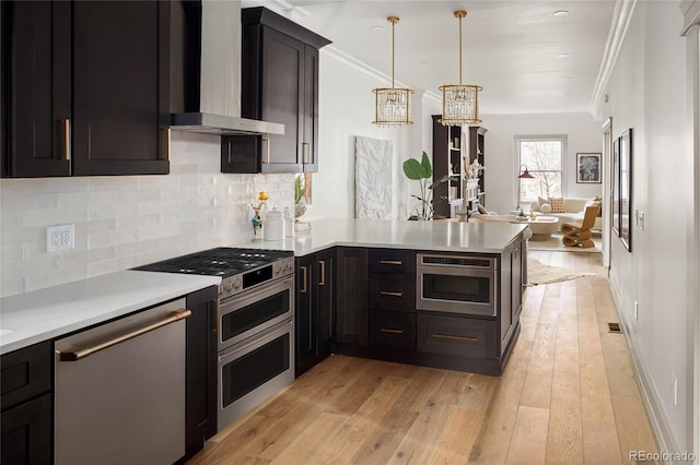 3142 W 26th Ave, Denver, CO 80211 - kitchen featuring wall chimney exhaust hood, stainless steel appliances, a peninsula, light countertops, and light wood finished floors