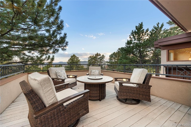 wooden terrace featuring an outdoor living space with a fire pit