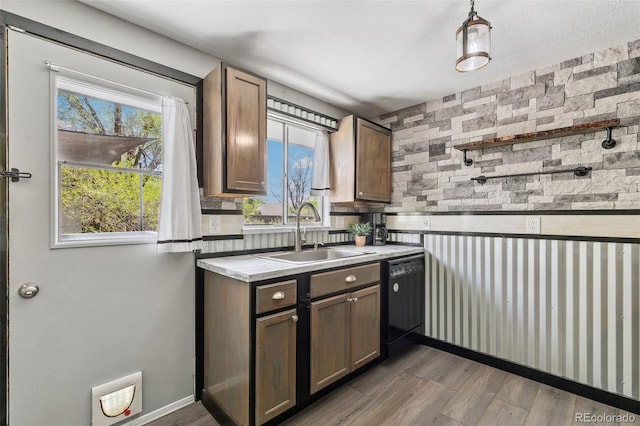 4475 London Ln, Colorado Springs, CO 80916 - kitchen featuring black dishwasher, dark wood-style floors, light countertops, a sink, and a wealth of natural light