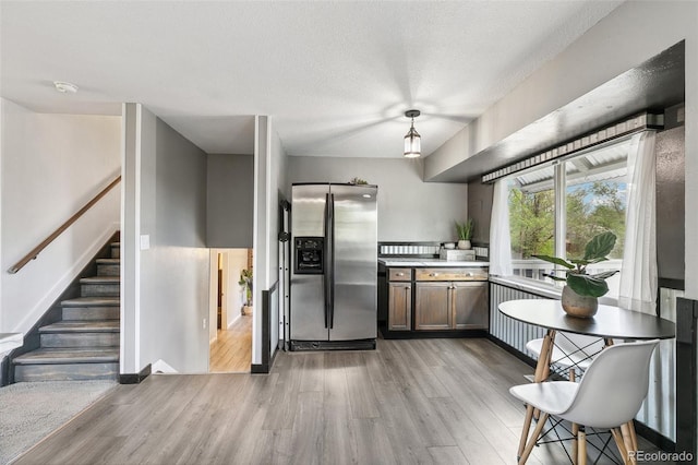 4475 London Ln, Colorado Springs, CO 80916 - kitchen featuring light wood-style floors, stainless steel fridge with ice dispenser, baseboards, and light countertops