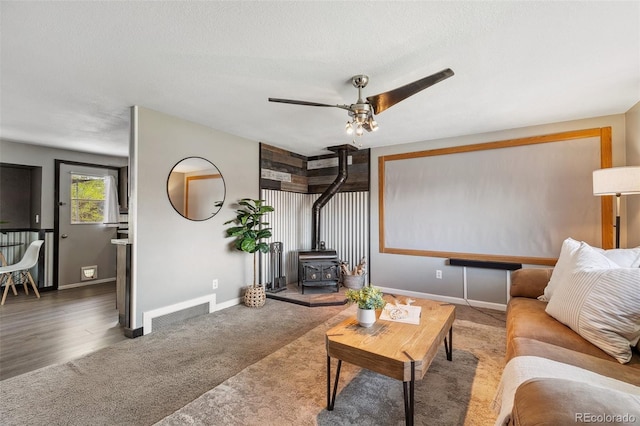 4475 London Ln, Colorado Springs, CO 80916 - carpeted living room with baseboards, a wood stove, ceiling fan, and visible vents