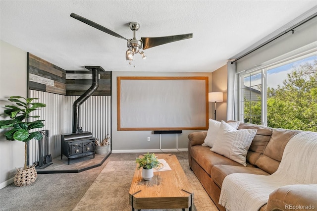 4475 London Ln, Colorado Springs, CO 80916 - carpeted living room featuring a textured ceiling, ceiling fan, baseboards, and a wood stove