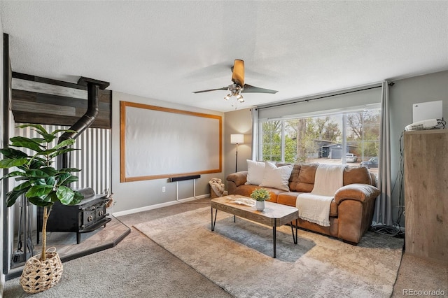 4475 London Ln, Colorado Springs, CO 80916 - living room featuring carpet floors, ceiling fan, a wood stove, and a textured ceiling