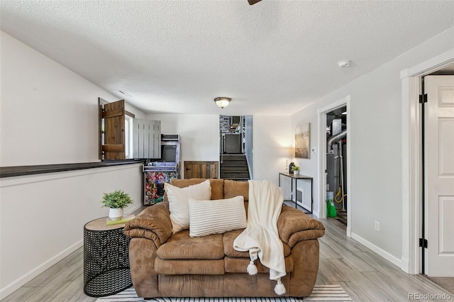 4475 London Ln, Colorado Springs, CO 80916 - living area featuring light wood-style floors, stairs, a textured ceiling, and baseboards
