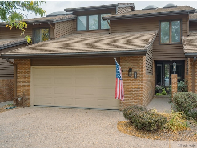 view of front facade featuring a garage, aphalt driveway, and brick siding