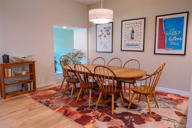 dining space with baseboards and wood finished floors