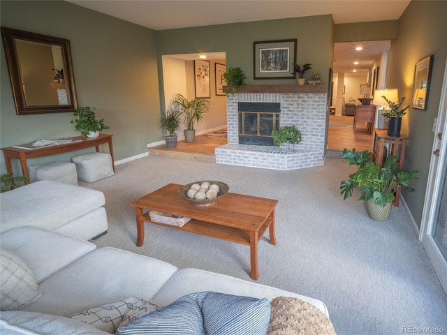 living room with carpet floors, a brick fireplace, and baseboards