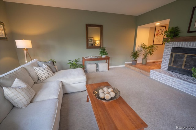 carpeted living room with a fireplace and baseboards