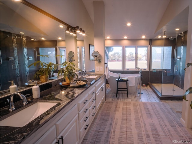 full bath featuring a freestanding bath, vaulted ceiling, a sink, and a shower stall