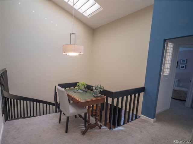 dining area with carpet floors, vaulted ceiling with skylight, and baseboards