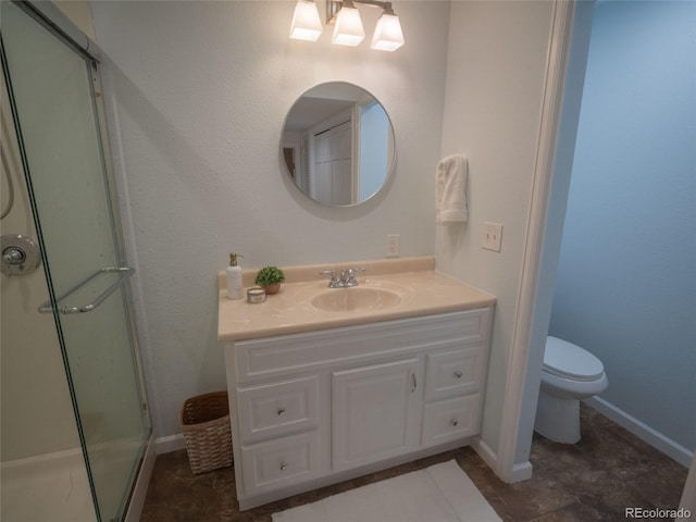 bathroom with a stall shower, baseboards, vanity, and toilet