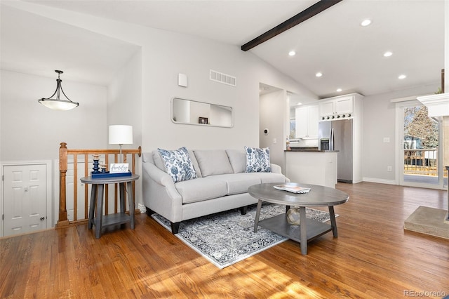 living room featuring baseboards, visible vents, vaulted ceiling with beams, recessed lighting, and light wood-type flooring